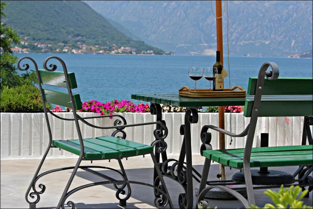 - une table avec deux chaises et une table avec des verres à vin dans l'établissement Accommodation Tomcuk, à Kotor