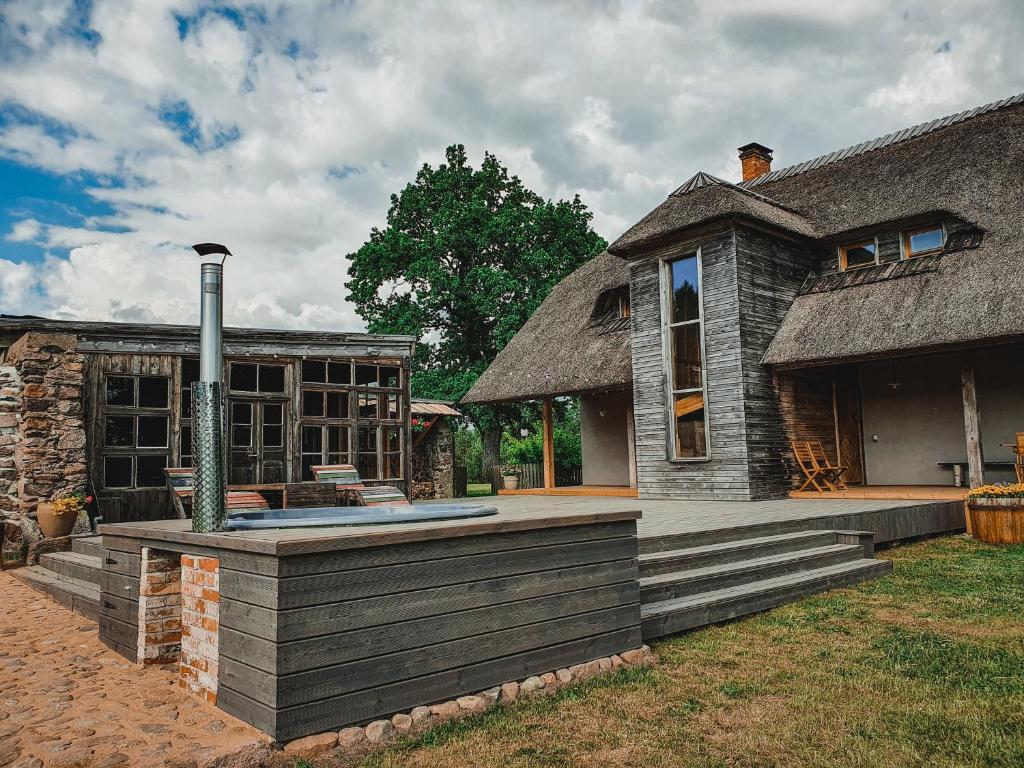 a house with a thatched roof and a patio at Pūjalgi in Ēdole