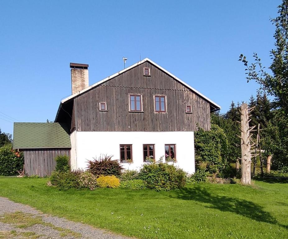 une grande grange blanche avec un toit noir dans l'établissement Chalupa bez hranic, à Krompach