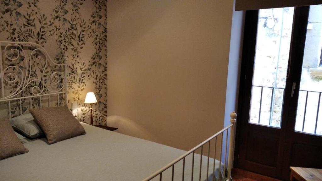 a small bedroom with a bed and a window at Habitación doble con baño compartido in Bas