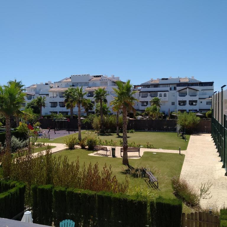 a park with palm trees and buildings in the background at Apartamento Carlos in Rota