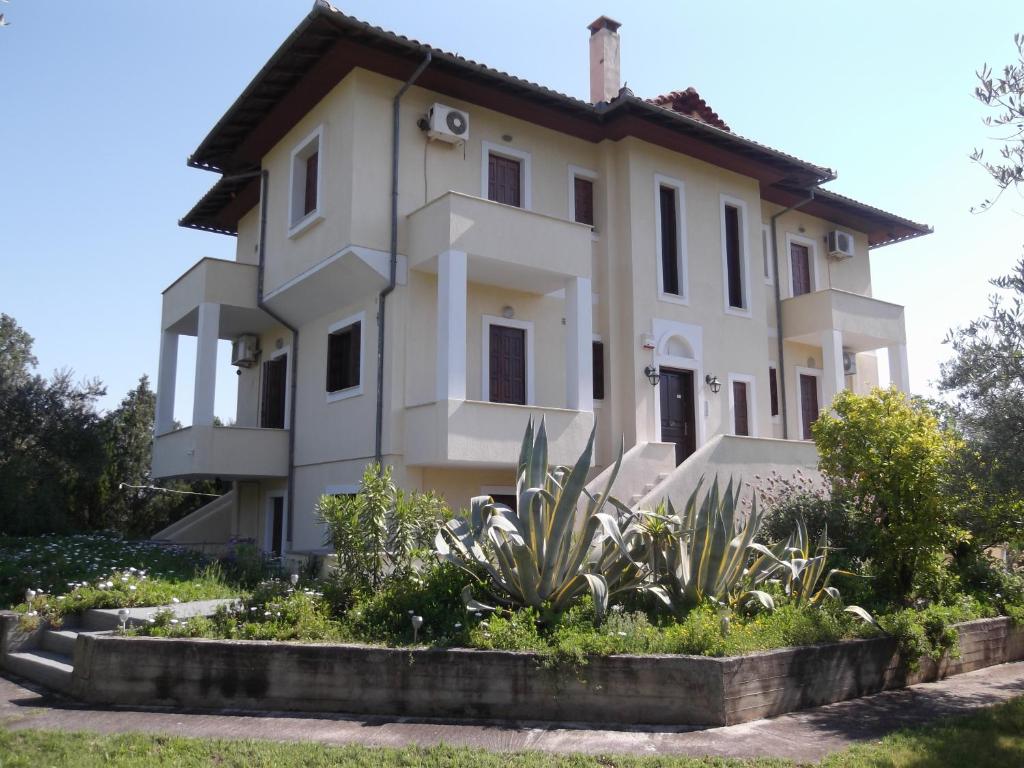 a white house with a garden in front of it at Villa Christina in Amaliapoli