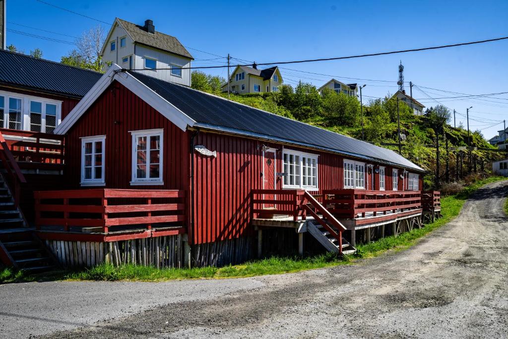 un bâtiment rouge avec des fenêtres blanches sur une rue dans l'établissement Klingenberg Rorbuer, à Sørvågen