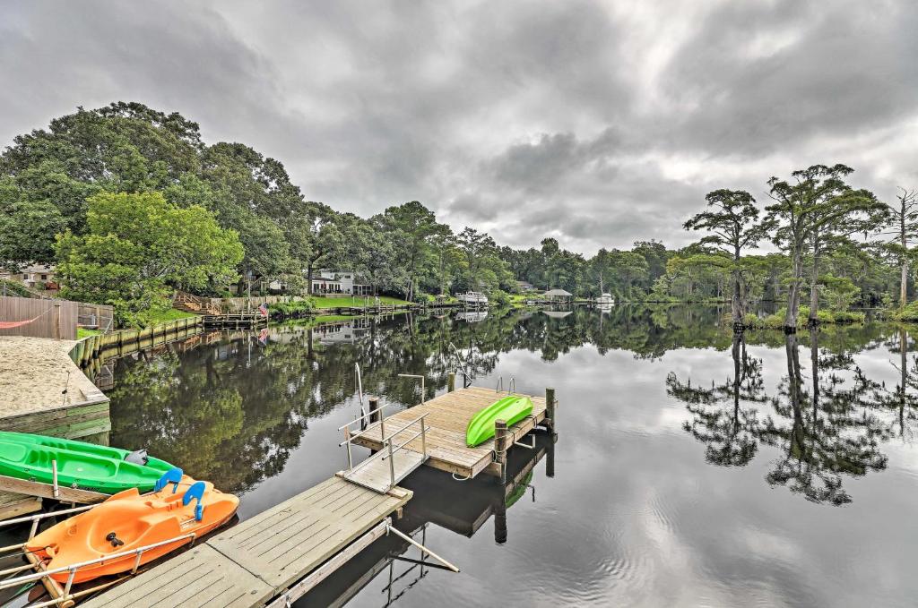a couple of boats docked at a dock on a lake at The Gosling Studio Cabin with River Access! in New Bern