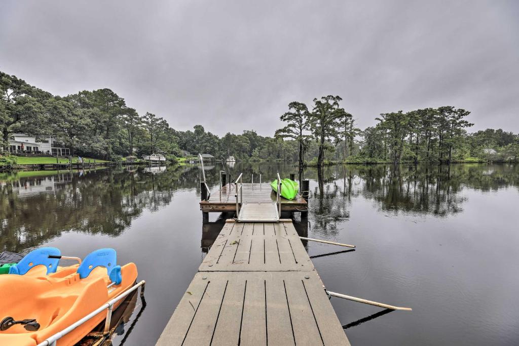 un muelle con dos barcos en un lago en Cottage with Patio and Shared Waterfront Perks!, en New Bern