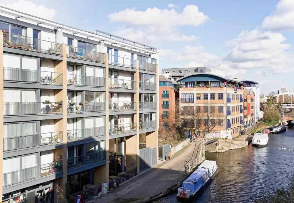 a building next to a river with a boat at Modern rooms in central London in London