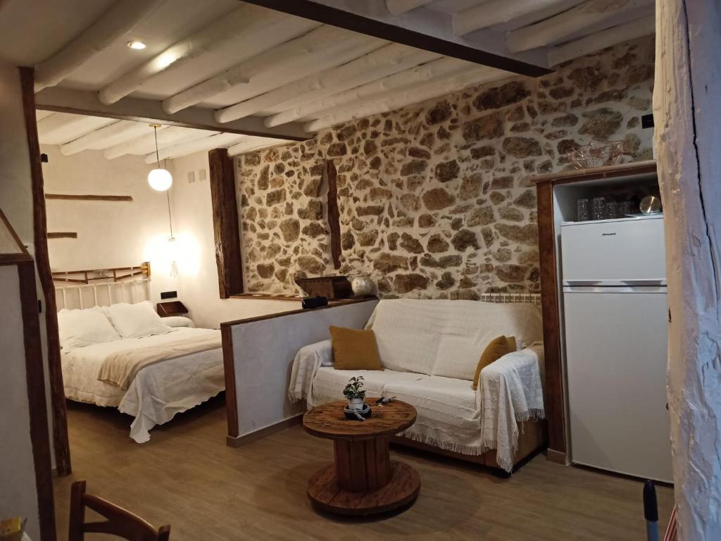 a living room with a couch and a bed and a table at Apartamento La Herrerita in Candelario