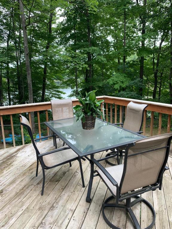 a table and chairs on a deck with a potted plant at Tibbets Lake House in Traverse City