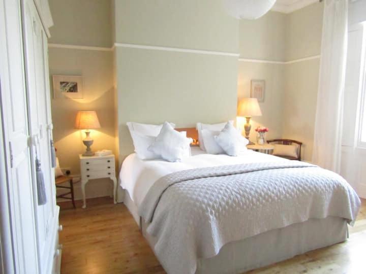 a bedroom with a large white bed with two lamps at Crouch End Apartment - Free Parking in London