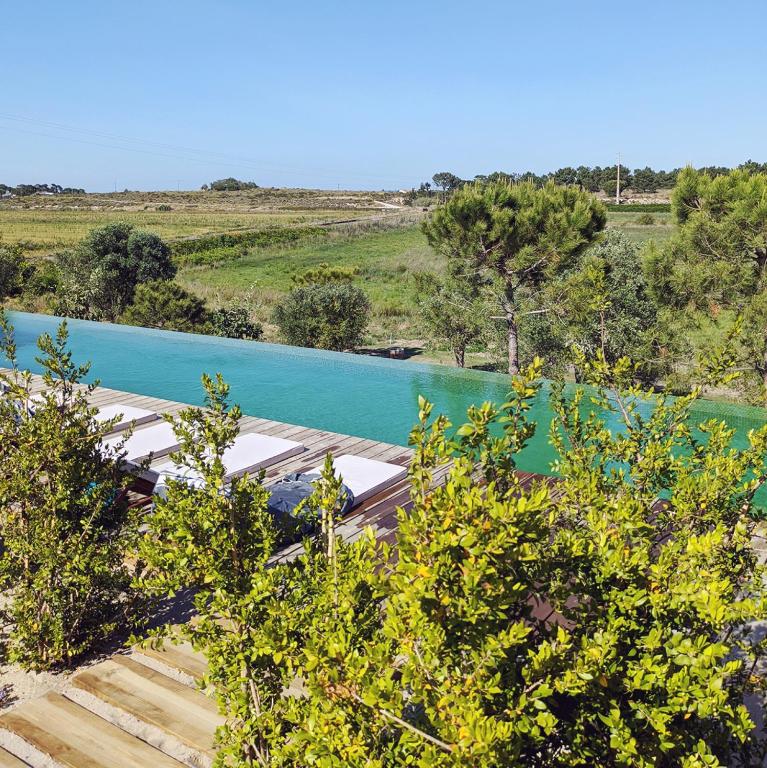 uma vista para um rio com água azul em Casas de Arroz na Comporta