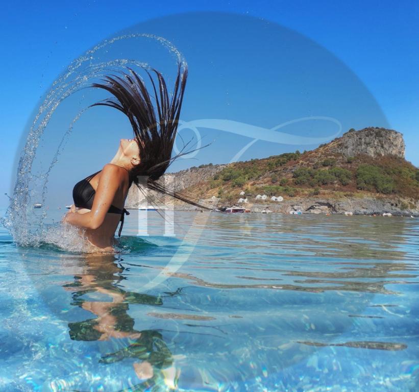 a woman in the water with a splash at Hotel TEA - Praia a Mare in Praia a Mare
