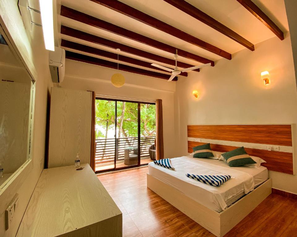 ein Schlafzimmer mit einem Bett und einem großen Fenster in der Unterkunft The Pearl Seaview in Fulidhoo