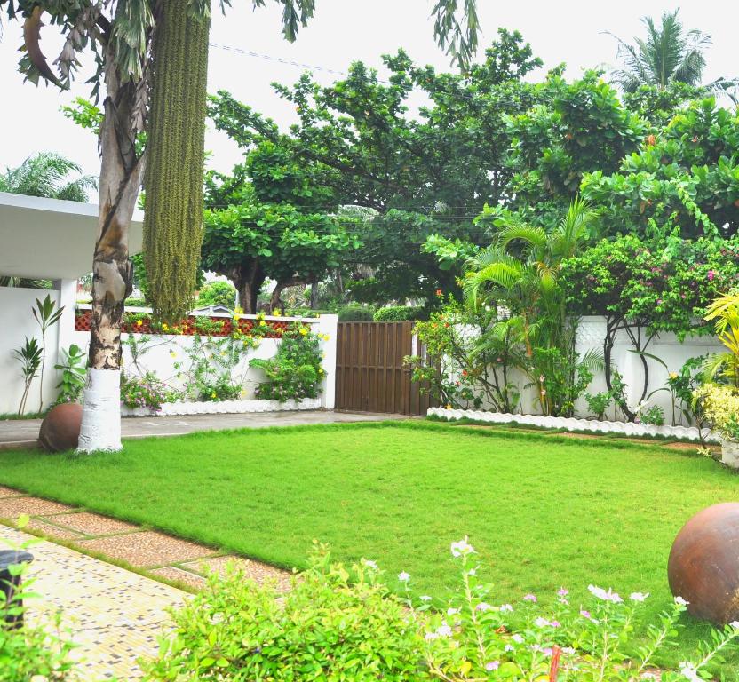 a garden with a yard of grass and trees at Villa Ekabo in Cotonou