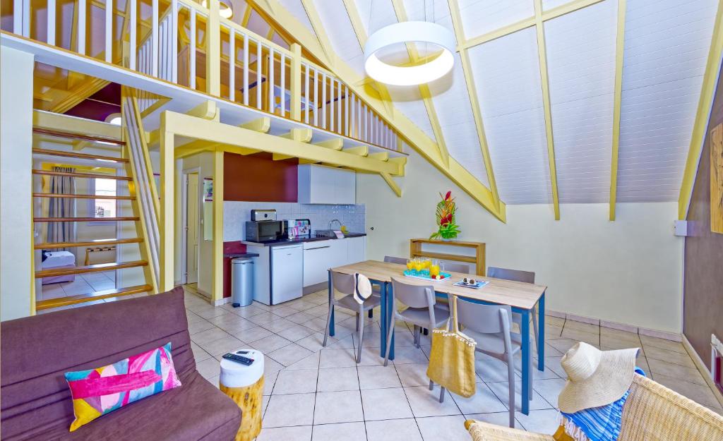 cocina y sala de estar con mesa y sillas en Village Creole en Les Trois-Îlets