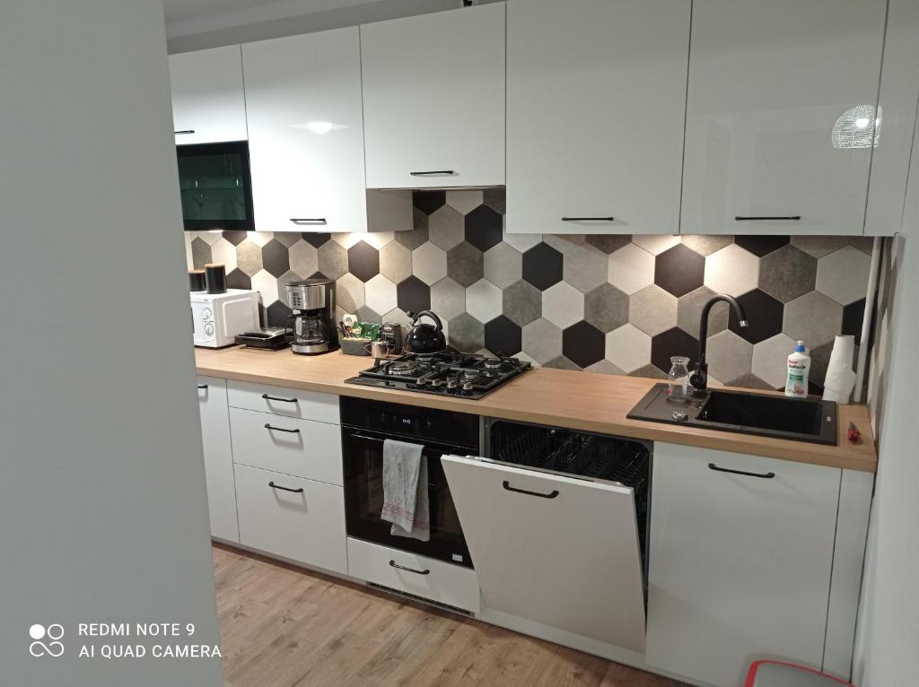 cocina con armarios blancos y fogones en Apartament na parterze en Stalowa Wola