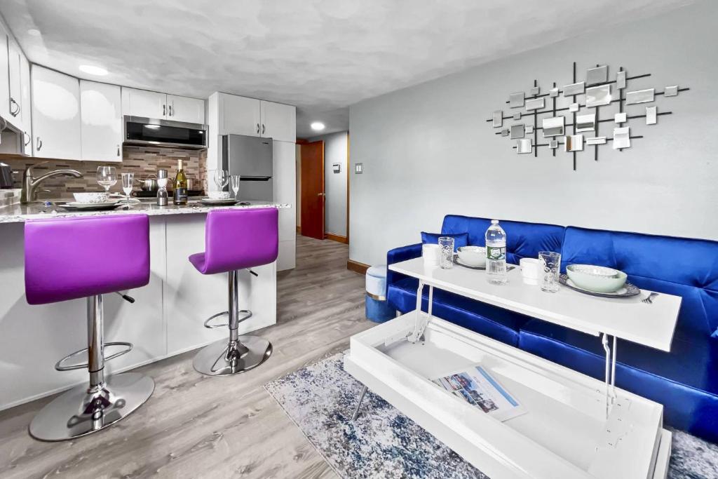 a living room with a blue couch and a kitchen at Suite at House of L in Chelsea