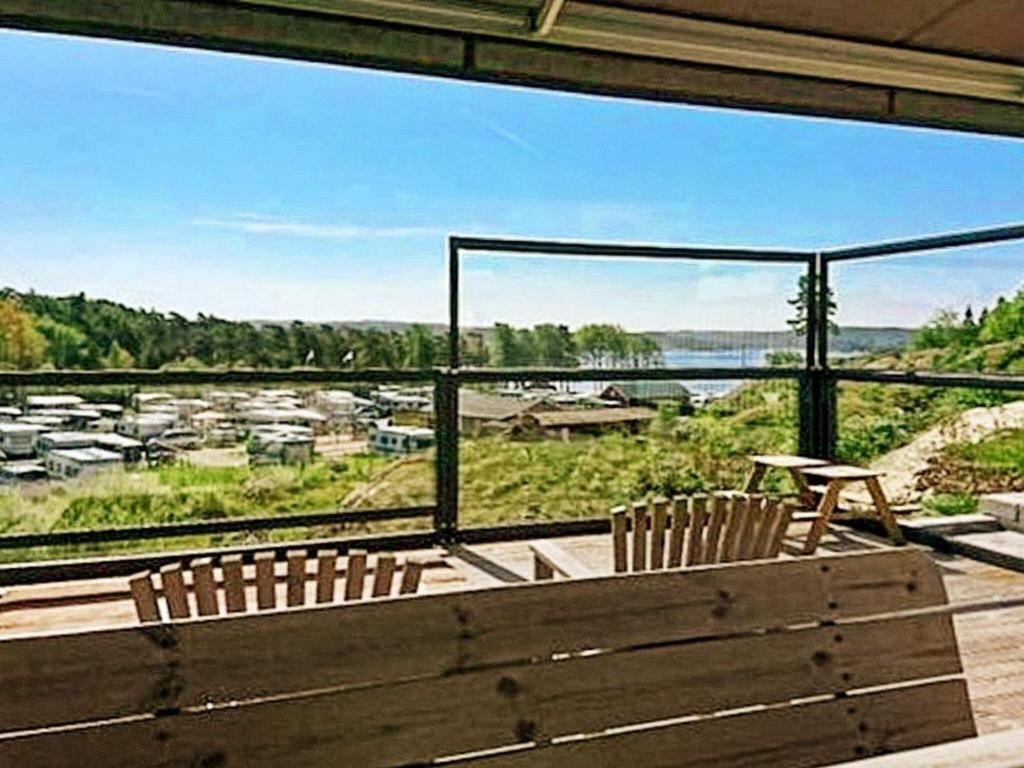 斯特伦斯塔德8 person holiday home in STRÖMSTAD的阳台设有长凳,享有城镇美景。