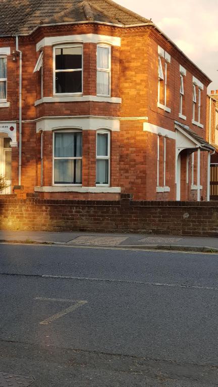 a brick building on the side of a street at Palmerston House, 5 Bed sleeps 12 in Spon End