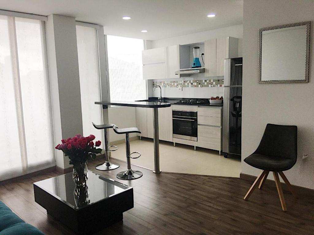 uma sala de estar com uma cozinha com mesa e cadeiras em Espectacular apartamento con estacionamiento gratuito Chía N 2 em Chía