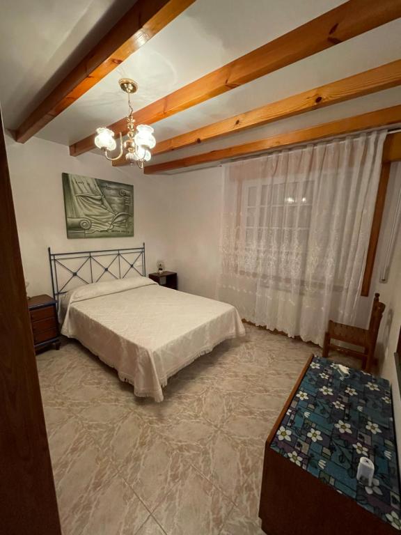 1 dormitorio con cama y ventana grande en La Favorita, en Pontevedra