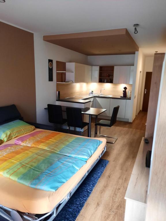 a bedroom with a large bed and a kitchen at Appartement am Ossiachersee in Villach