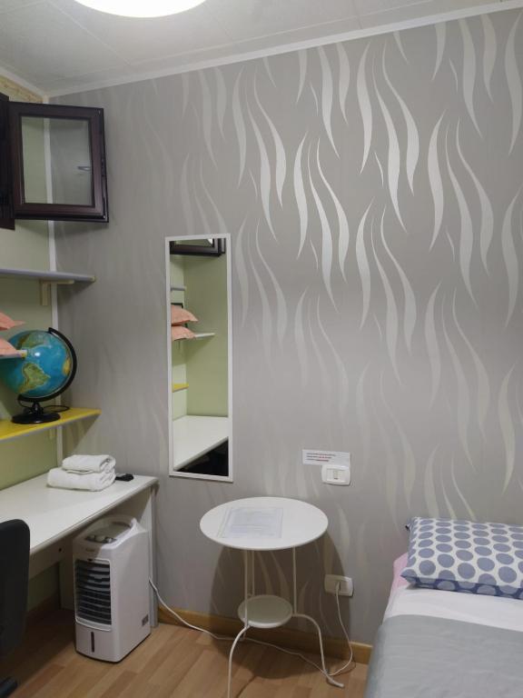 sypialnia z łóżkiem, biurkiem i lustrem w obiekcie B&b L'Oasi del Vulture w mieście Rapolla