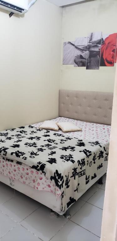 ein Schlafzimmer mit einem Bett mit einer schwarz-weißen Bettdecke in der Unterkunft Apart Hotel Fazenda Monte Castelo - Gravatá in Gravatá