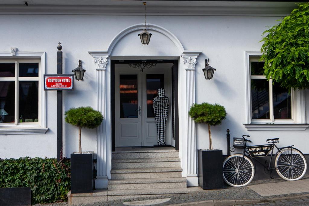 a bike parked in front of a white house at Boutique Hotel Massimos in Námestovo