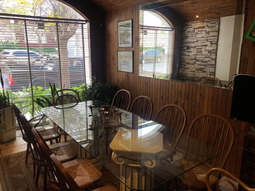 una sala da pranzo con tavolo in vetro e sedie di varesse house a Mar del Plata