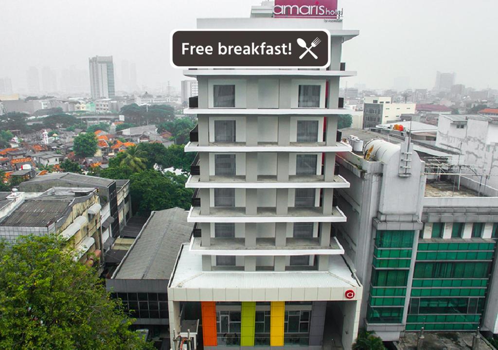 un bâtiment avec un panneau de petit-déjeuner gratuit au-dessus dans l'établissement Amaris Hotel Fachrudin – Tanah Abang, à Jakarta