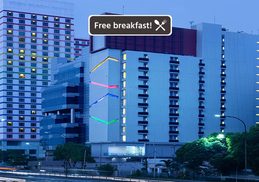 a building with a free breakfast sign on it at Amaris Hotel Slipi in Jakarta