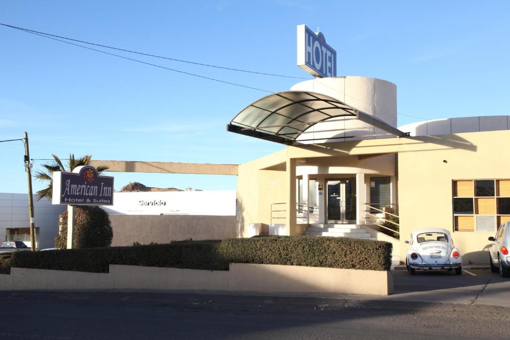 a small white car parked in front of a hotel at American Inn Hotel & Suites Parral in Hidalgo del Parral