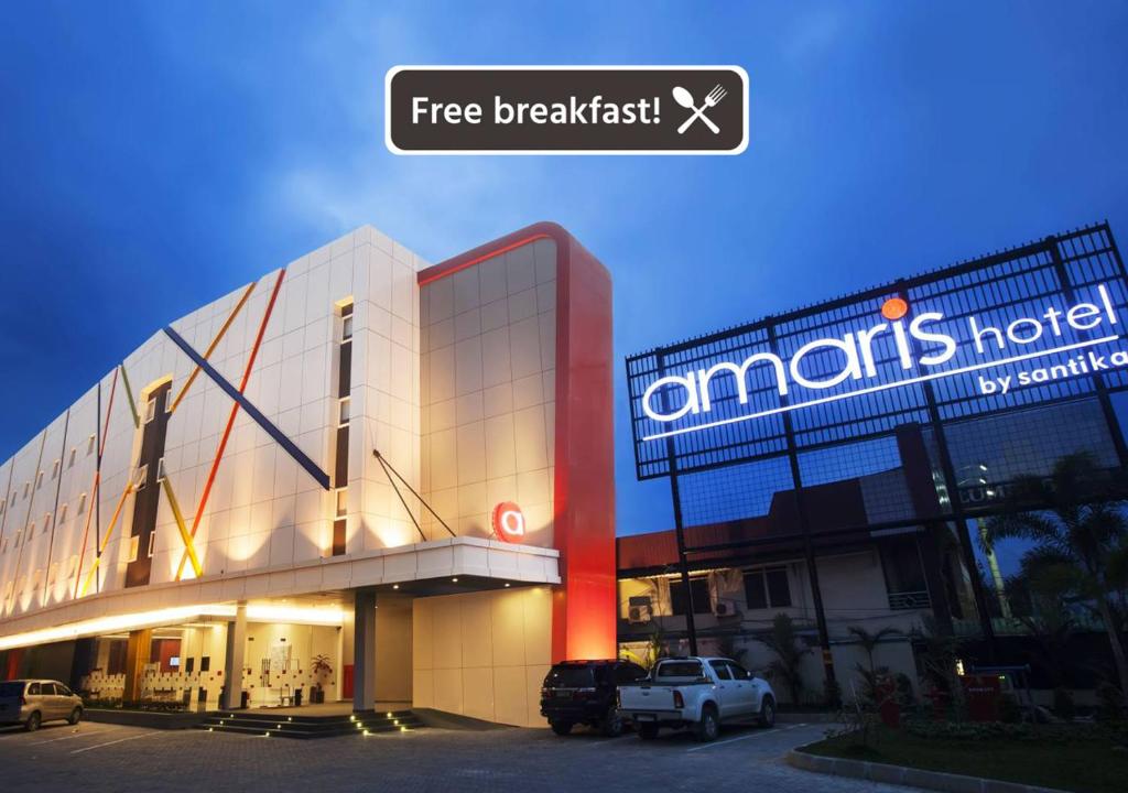 un bâtiment avec un camion garé devant lui dans l'établissement Amaris Hotel Samarinda, à Samarinda