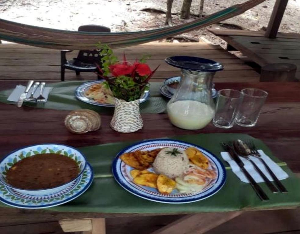 una mesa cubierta con platos de comida y leche en Reserva Natural Selva Mojada, en Nuquí