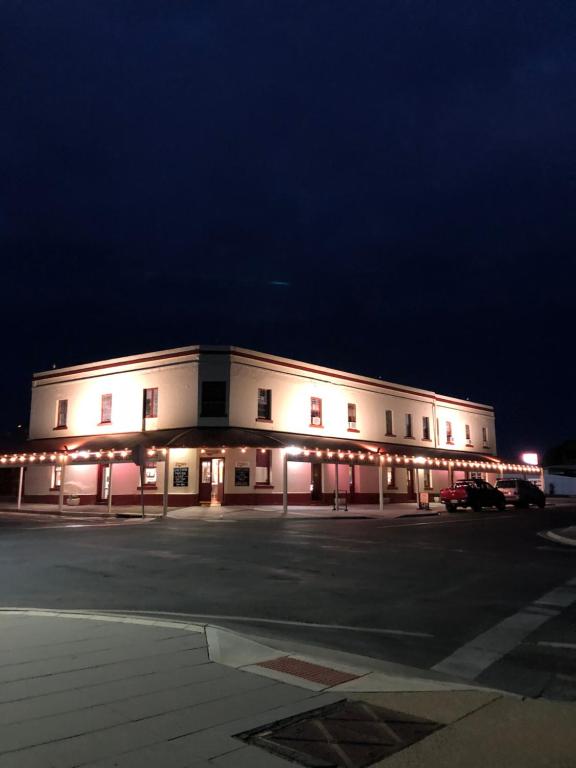 a large white building with a parking lot at night at Cornucopia hotel in Wallaroo