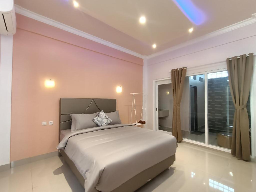 - une chambre avec un grand lit et une grande fenêtre dans l'établissement Bis homestay, à Sumbawa Besar