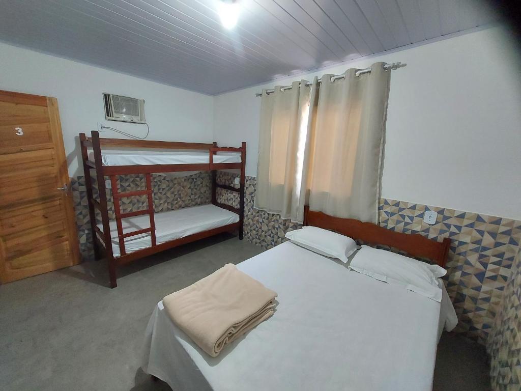 a bedroom with two bunk beds and a ladder at Pousada do Leô in Mangaratiba