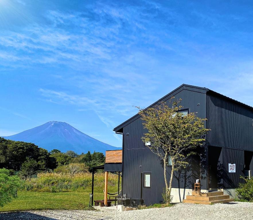 a black building with a mountain in the background at SILVER SPRAY MtFuji view Yamanakako in Yamanakako