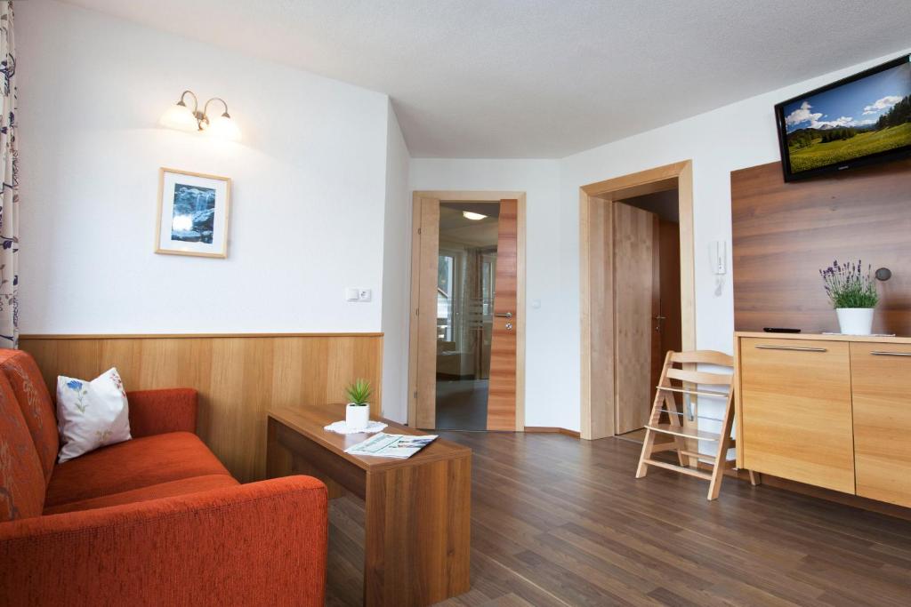 salon z czerwonym krzesłem i stołem w obiekcie Ferienhaus Luis w mieście Nauders