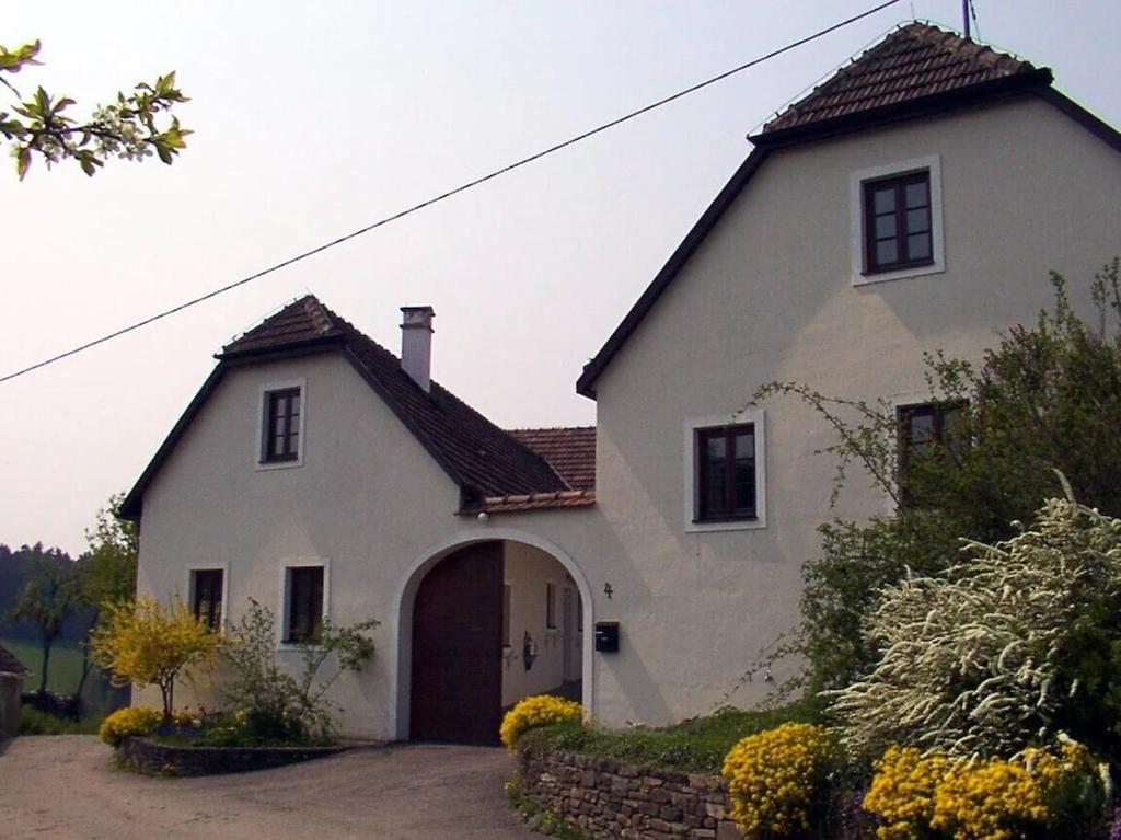Friedersdorf的住宿－Hof Grünfelder，一座大型白色房屋,设有车库