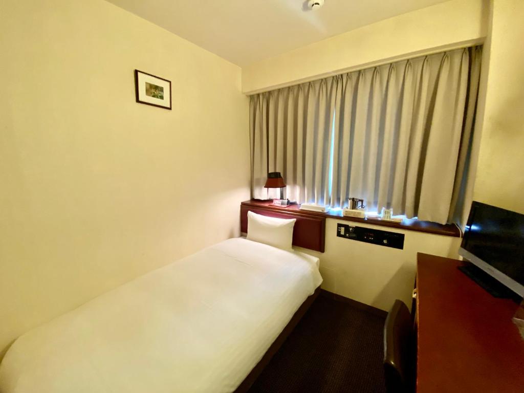 Säng eller sängar i ett rum på Smile Hotel Sasebo