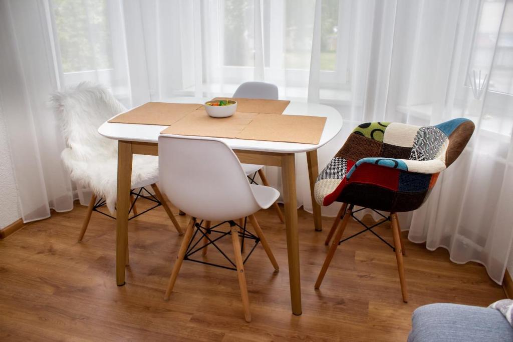 una mesa con dos sillas y un tazón en ella en Liepu Apartment, en Liepāja