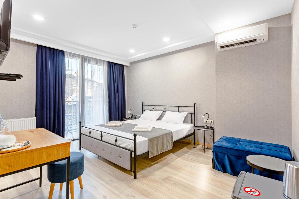 a bedroom with a bed and a table and chairs at Monument1880 in Tbilisi City
