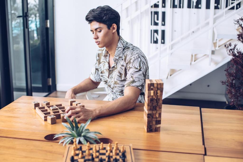 a man sitting at a table playing chess at Blu Monkey Hub and Hotel Phuket Town- Free All Day Coworking space in Phuket Town