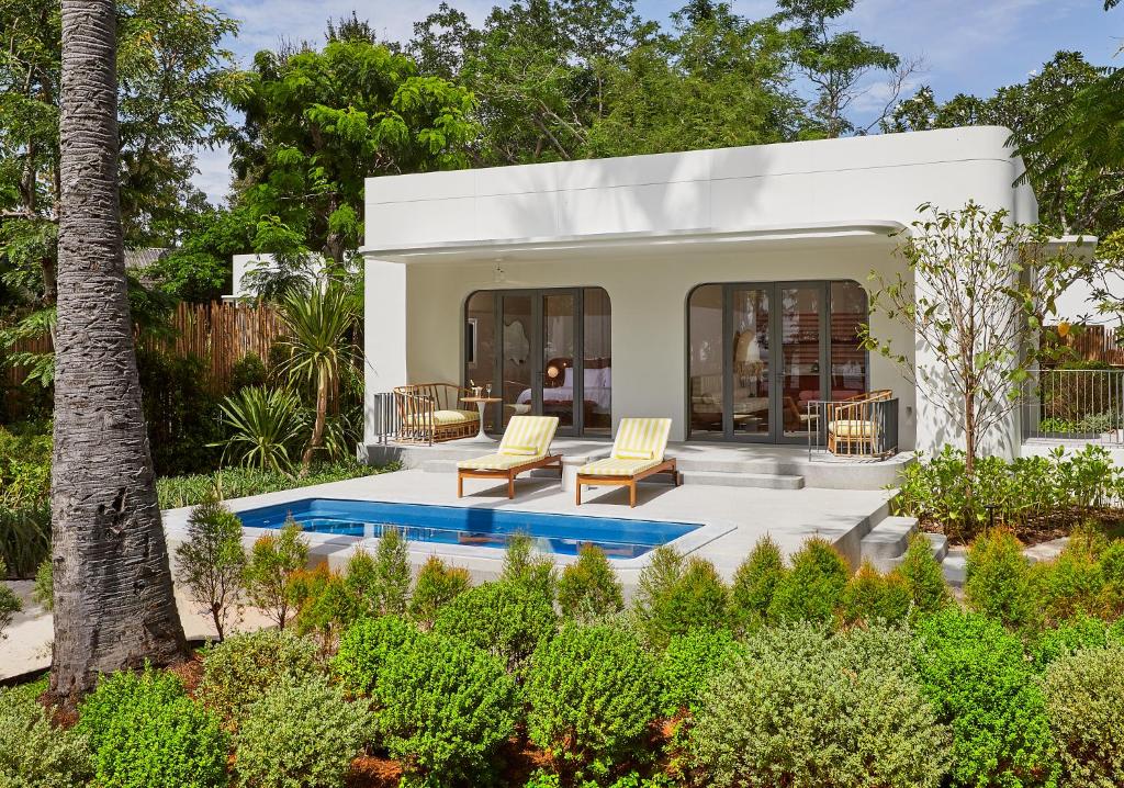a villa with a swimming pool in a garden at The Standard, Hua Hin in Hua Hin