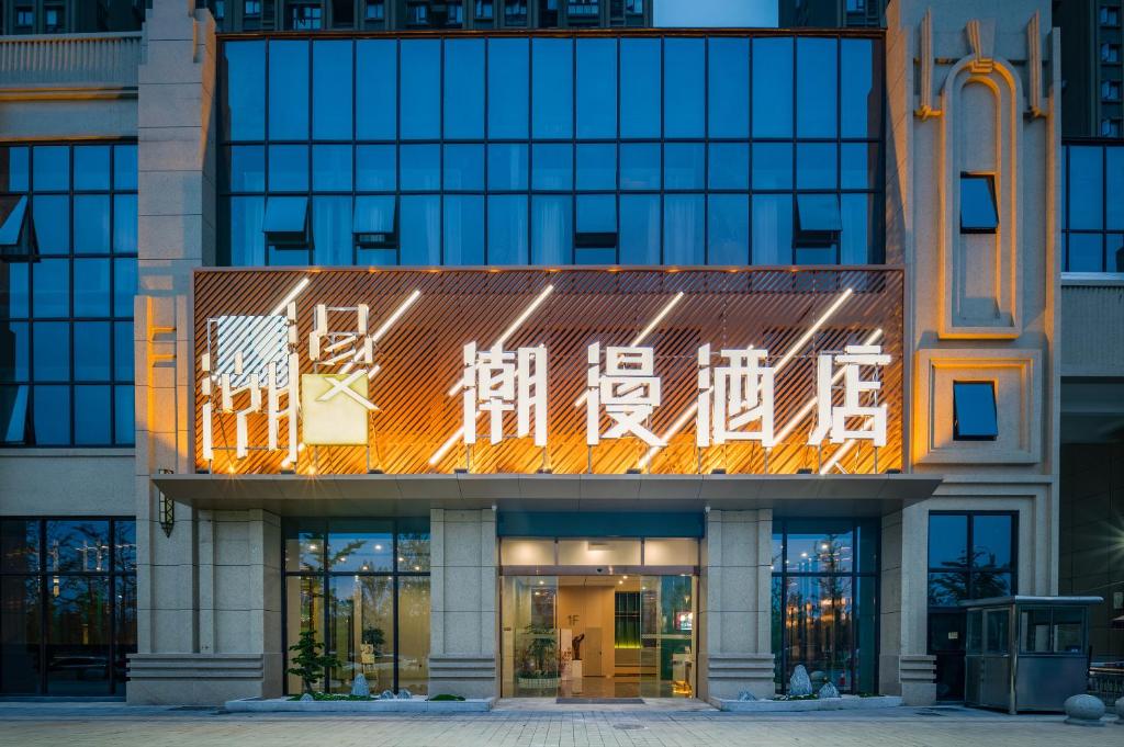 a building with a sign on the front of it at Chaoman Hotel in Jingzhou
