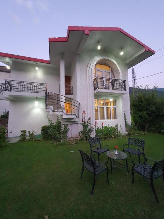 una casa con sillas y una mesa en el patio en Villa 5, en Manali