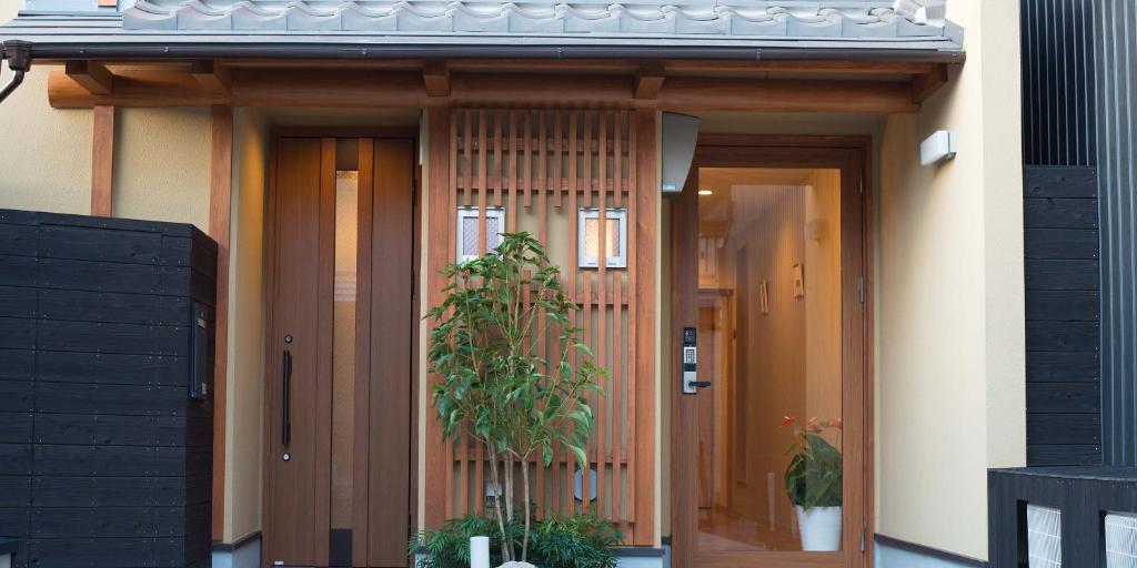 une maison avec deux portes et une usine devant elle dans l'établissement Kyo-Anthu Inn, à Kyoto