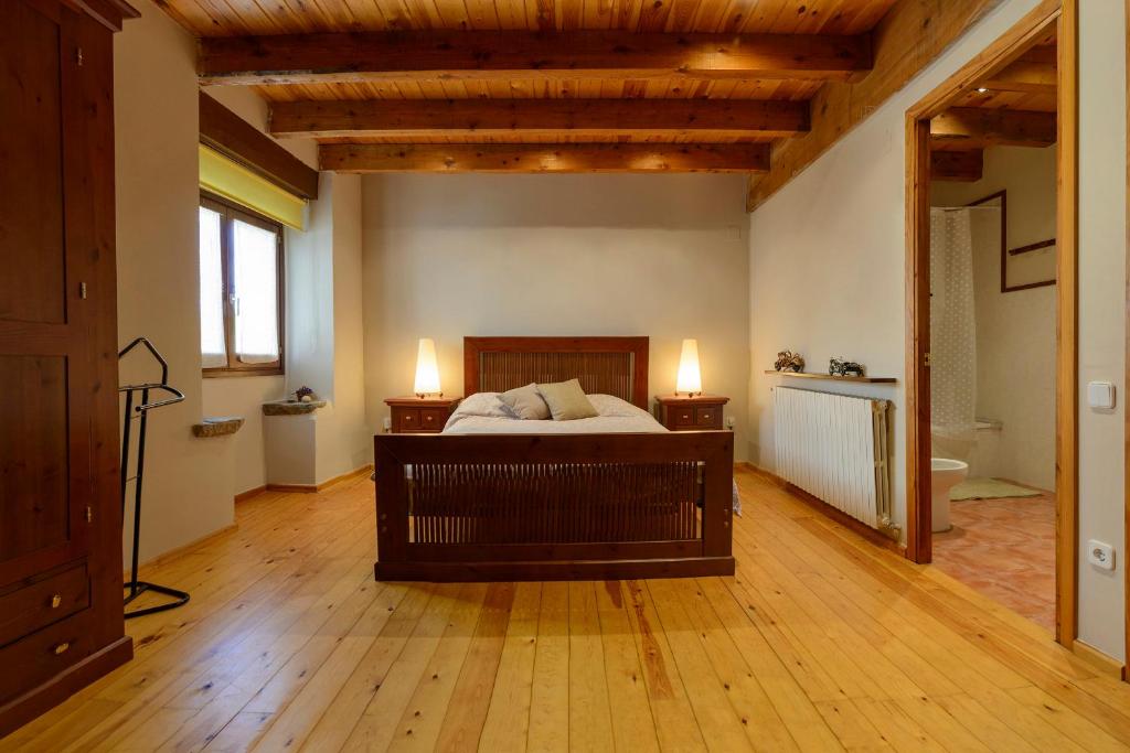 a bedroom with a bed and two lights on the wall at Suite en casa rural in Bas