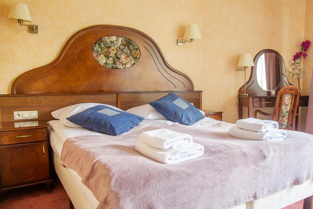 a bedroom with a large bed with towels on it at AL-DOM apartamenty Róża 101 in Kołobrzeg